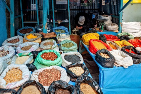 Colourful spices and grains in sacks on a market stall, variety and aromas create a lively