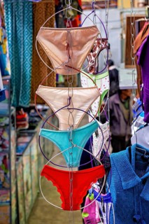 Colourful underwear hanging on chains in a lively market shop, selling women's panties in the