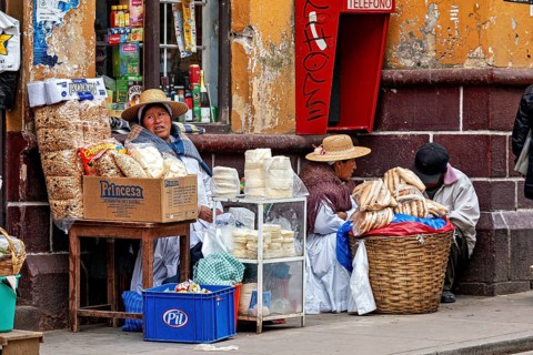 Women selling traditional food at a street stall in Peru, Bolivian Indio woman selling goods in the