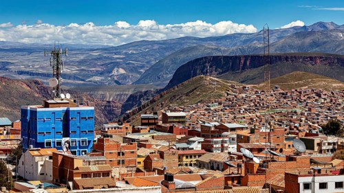 Urban landscape with red tiled roof architecture and a telecommunications tower in front of a