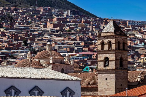 Historic cityscape with towers and densely built-up areas under a blue sky, view over the city of