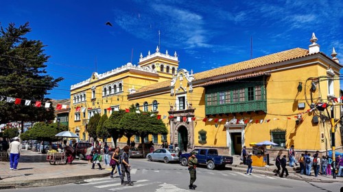 Colonial-style building with market scene and decorative flags, The streets of the historic centre