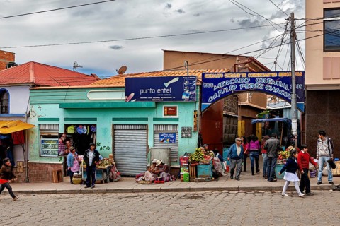 Entrance to a market with fruit stalls and passers-by, people in the streets of Potosi in Bolivia