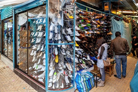 Shoe shop with shelves full of colourful shoes and people shopping, people in the streets of Potosi