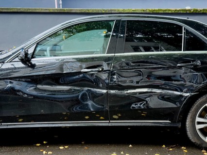 Dented car door after traffic accident, significant bodywork damage to a car in Wuppertal, Germany