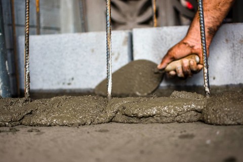 Close-up of a construction worker spreading mortar with a brick trowel