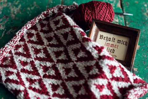 Knitted piece with ball of wool and framed picture with the lettering Behalt ich immer lieb