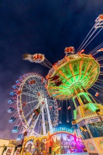 Folk festival time in Stuttgart. Ferris wheel and chain carousel in the evening. The 178th