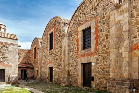 Historic stone buildings with tile accents and curved roofs under a blue sky, The historical museum