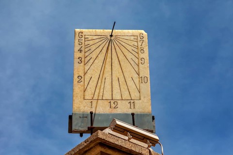 Classic stone sundial with clear dial and hands against a sunny background, The sundial of Potosi
