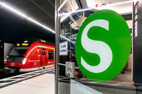 S-Bahn arriving underground at the main station stop. Platform with travellers and logo. Stuttgart,