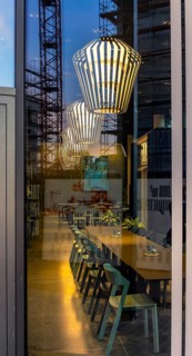 The picture shows the interior of a modern Berlin pub, taken in the evening. The scene is