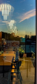 The picture shows the interior of a modern Berlin pub, taken in the evening. The scene is