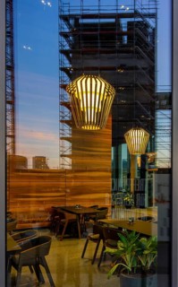 The picture shows the interior of a modern Berlin pub, taken in the evening. The scene is