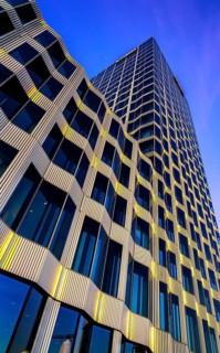The picture shows a modern office and commercial building at the central station, warm evening