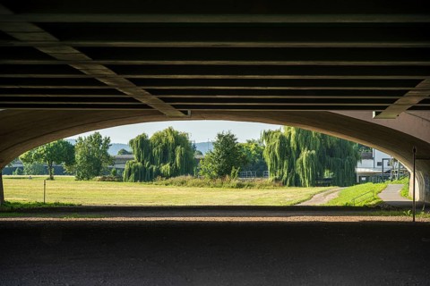View under a bridge onto a summer landscape with willow trees, Minden waterway junction,