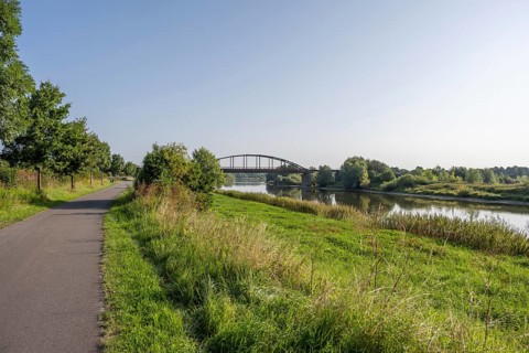An idyllic river with a bridge surrounded by a green landscape under a clear sky, Weser, Weser