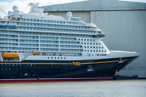 A side view of a cruise ship with distinctive lettering near a shipyard, cruise ship at the Meyer