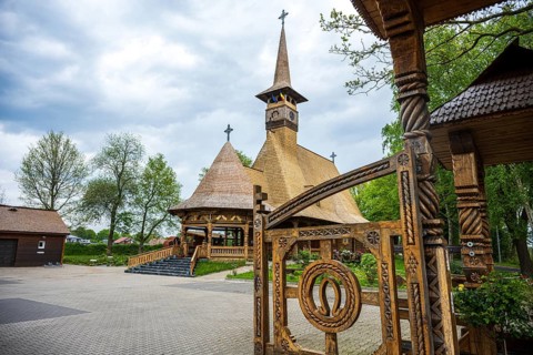 Unique wooden church with ornate carvings and horse shoes on the Tor tor, surrounded by trees, The