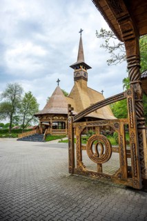 Artfully carved wooden church with horseshoes on the Tor tor in front of a cloudy sky, The Romanian