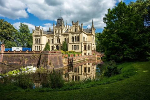 Gothic castle in perspective with moat surrounded by green landscape, Evenburg Castle, Leer, East