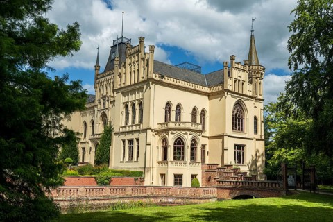A Gothic castle with architectural details and surrounded by trees, Schloss Evenburg, Leer, East
