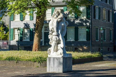 Detailed statue in front of a historic building with clear lines and soft shadows, statue The