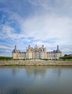 The symmetrical Château de Chambord is reflected in the still water, highlighting its magnificent