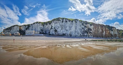 Panoramic view of Dieppe beach in Normandy, France. Majestic white chalk cliffs rise above a pebble
