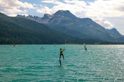 Kitesurfing on Alpine Lake Silvaplana in a Sunny Summer Day with Mountain View in the Swiss Alps in