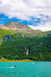 Kitesurfing on Alpine Lake Silvaplana in a Sunny Summer Day with Mountain View in the Swiss Alps in