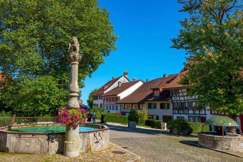 Medieval Old City Square with House and Water Fountain in a Sunny Summer Day with Blue Sky in