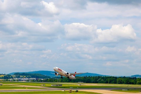 Swiss Airlines Passenger Airplane Take Off From the Runway and Flying Against Blue Sky and Clouds