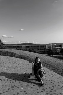 Nature Park with Panoramic View and Modern Building and a Woman Sitting on a Chair in a Sunny