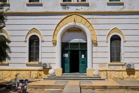 Historic building with arched entrance and small windows, bicycle in front, Historicism, Art Deco,