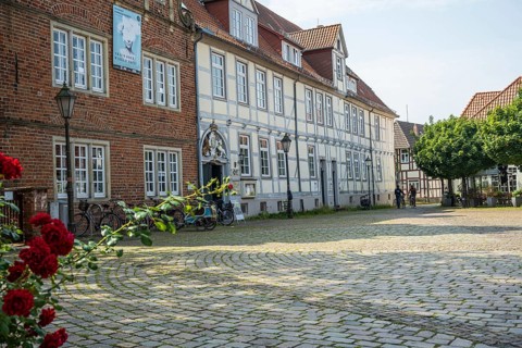 Half-timbered houses with red roses in a cobbled courtyard. Peaceful and historic scenery, Verden