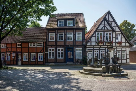 Row of traditional half-timbered houses along a quiet, cobbled street in summer, Weser cycle path,