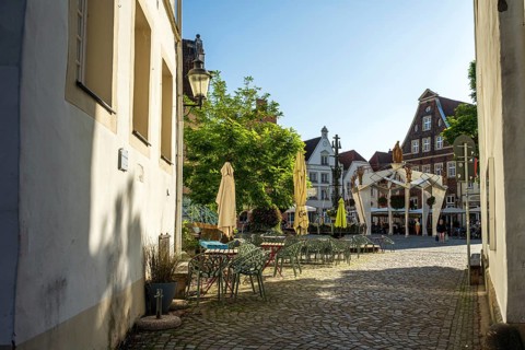 Idyllic alley with historic buildings and a cosy square in the sunshine, Warendorf, Münsterland,