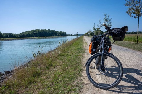 Bicycle on the riverside path under a clear sky. Sunny day with a view of the countryside,