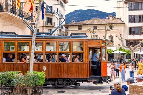 Vintage tramcar passing through town square in the centre of Sóller with tourists, Soller,