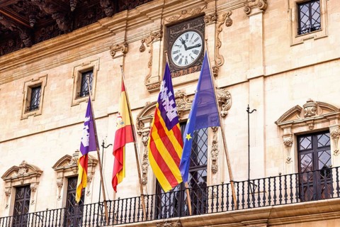 Spanish and Mallorcan flags with the EU flag on the balcony at city hall in Palma, Palma de