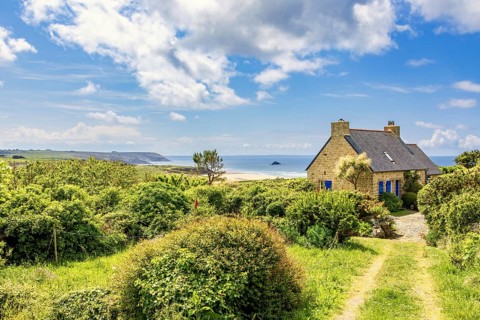 Idyllic old stone house with a seascape view at the sea horizon in a coastal landscape a sunny
