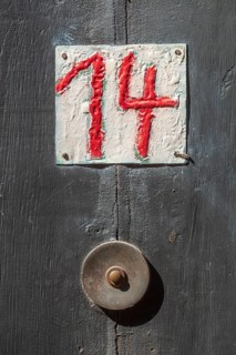 House number sign number fourteen and old doorbell on a half-timbered house in the old town centre,