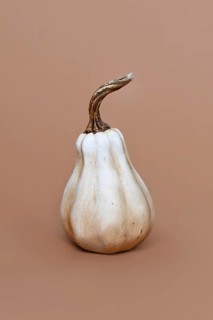 Single ceramic pumpkin ornament on brown background. Minimal autumn decoration object