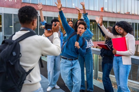 Young diverse students creating social media content together, vlogging on university campus while