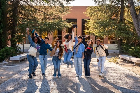 Group of excited multi ethnic students celebrating success and friendship, walking and jumping on a