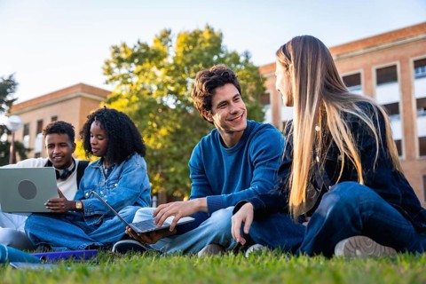 Group of diverse university students collaborating, studying, and engaging in conversations on the
