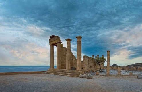 Ancient ruins of the Temple of Athena on the Acropolis of Lindos with columns in front of a calm