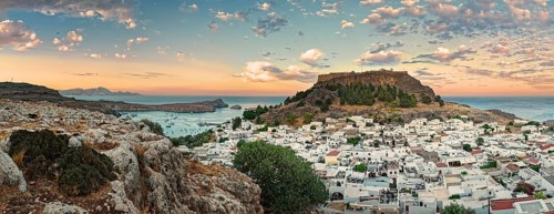 Panoramic view of the Greek town of Lindos by the sea with Acropolis at sunset with dramatic sky