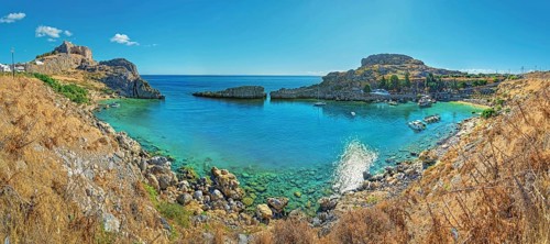 Clear panoramic view of Paulus Bay of Lindos with turquoise water and boats, Acropolis, Lindos,